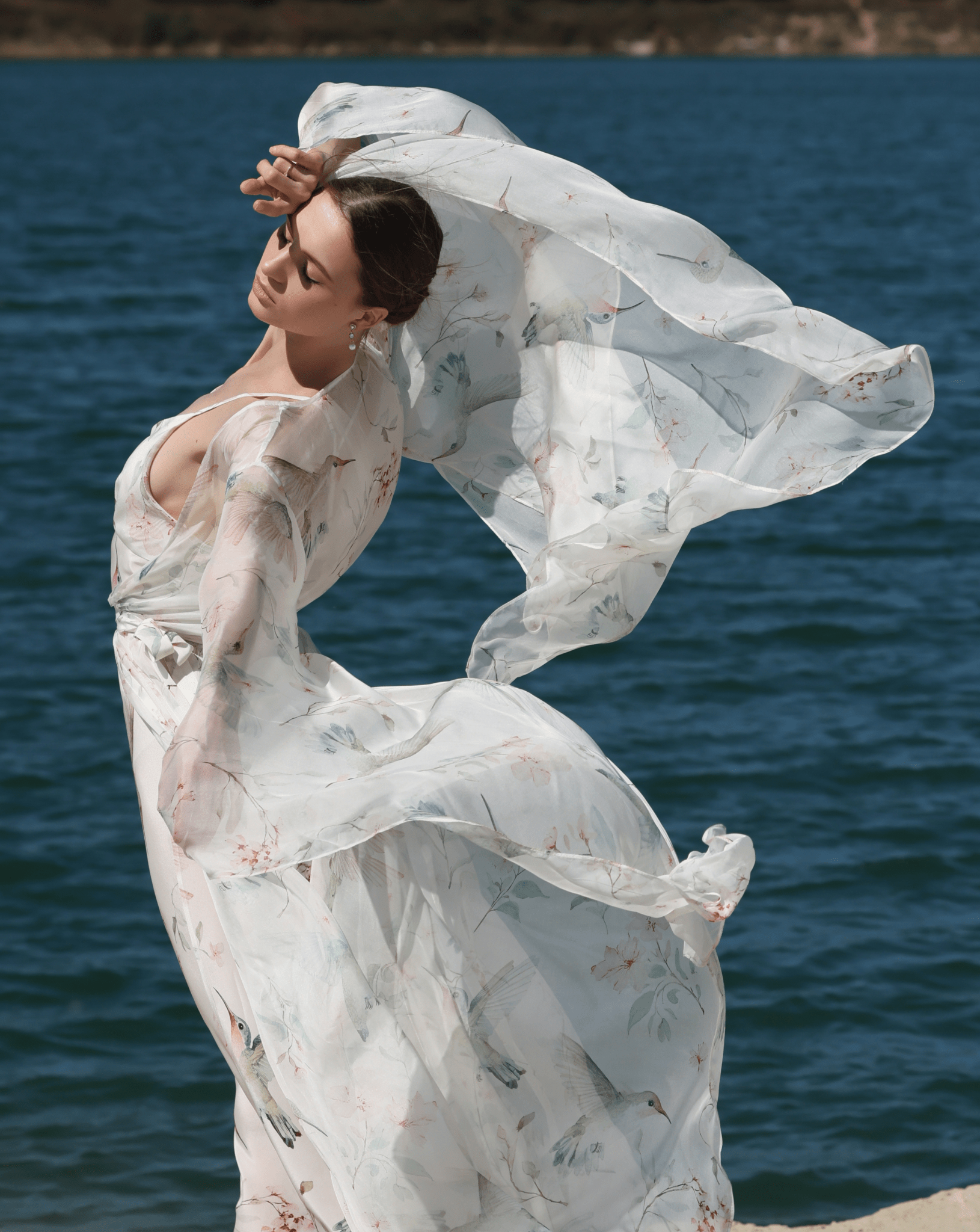 A poetic shot of the Silk Robe and Nightgown Set in motion, capturing the weightless silk chiffon as it flows by the water.