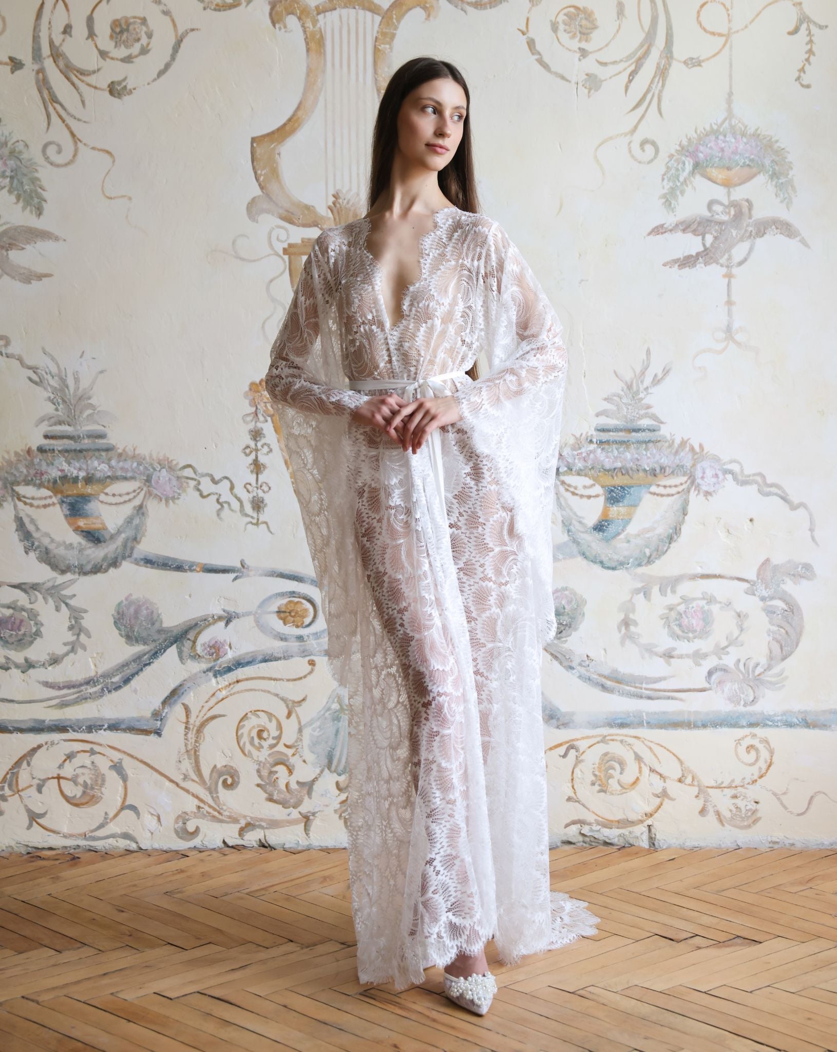 Full-length front view of the floor-length white lace robe, emphasizing its regal silhouette and lightweight fabric.