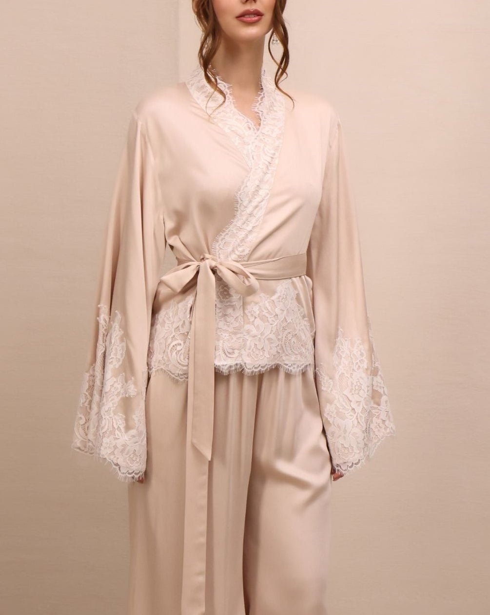 A mid-length shot of the Pyjamas Set, emphasizing the intricate lace-embellished wrap top and the elastic waistband.