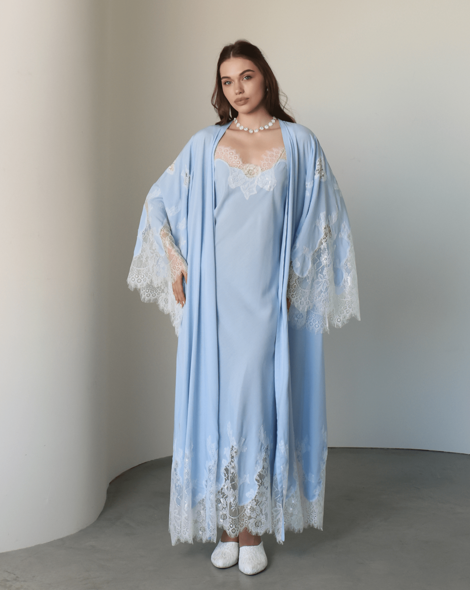 Frontal view of the attire with hands on hips, highlighting the exquisite lace detailing on the wide, elegant sleeves.