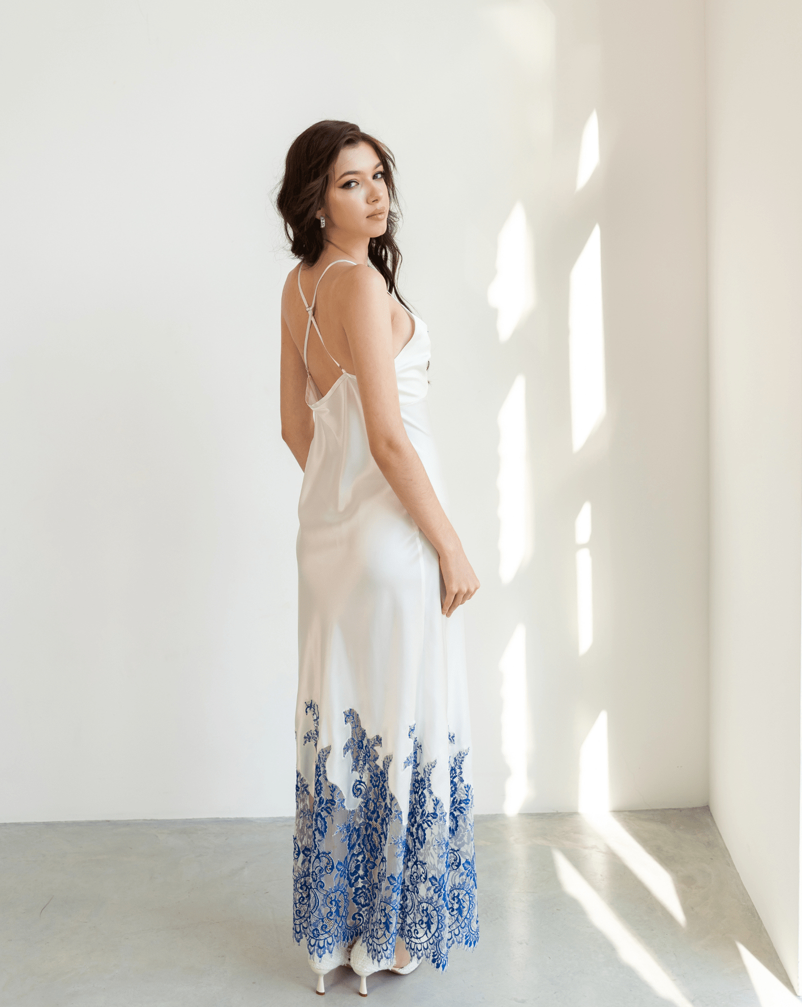 Side view of silk nightgown with blue lace hem and open back