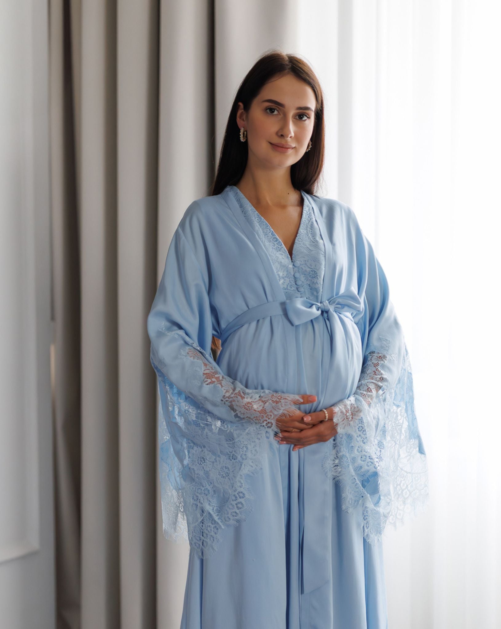 Pregnant woman wearing blue lace-trimmed maternity robe and nightgown set by Kafemme