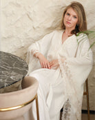 Seated pose on a chair, illustrating the effortless harmony of structure and softness in this maternity piece.