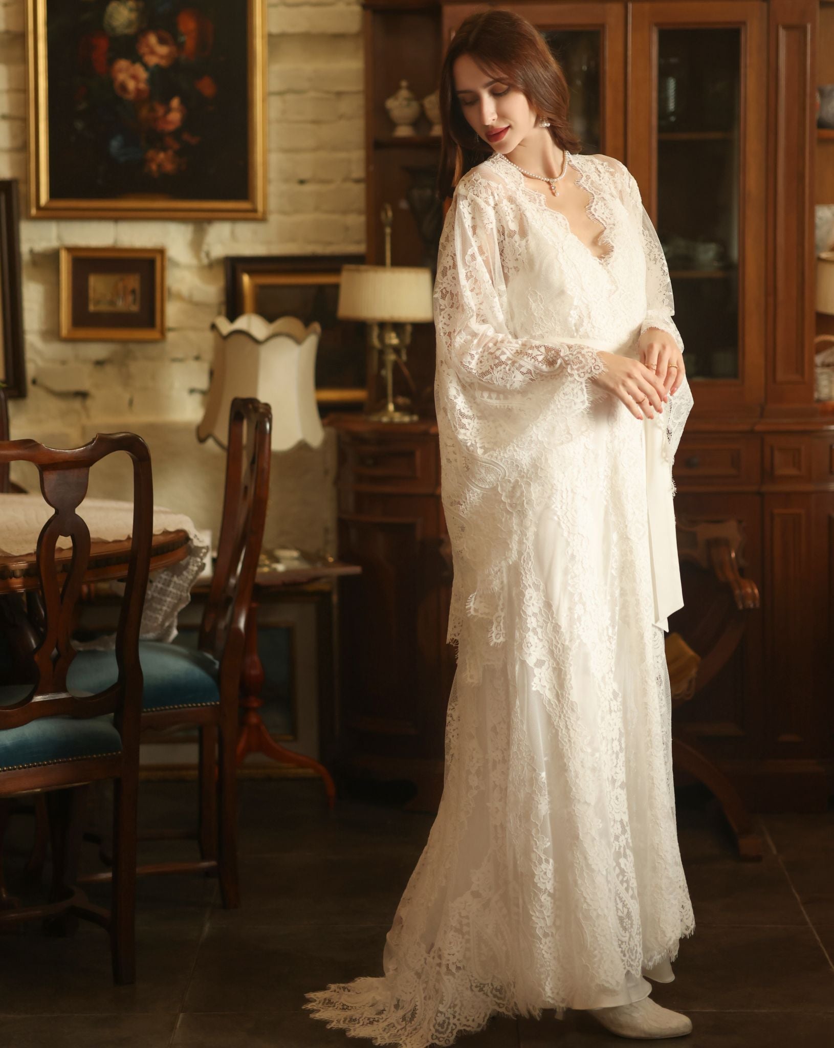 A full-length shot of the woman looking back at the flowing train of the robe, emphasizing its dramatic length.