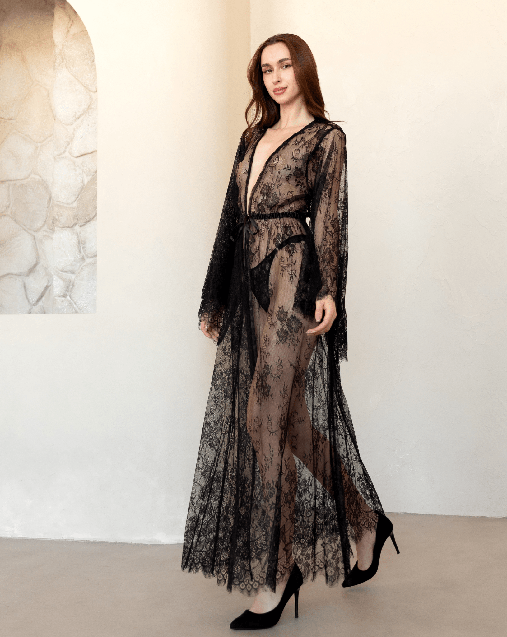 Model walking in a full-length black lace robe with floral embroidery and soft movement.