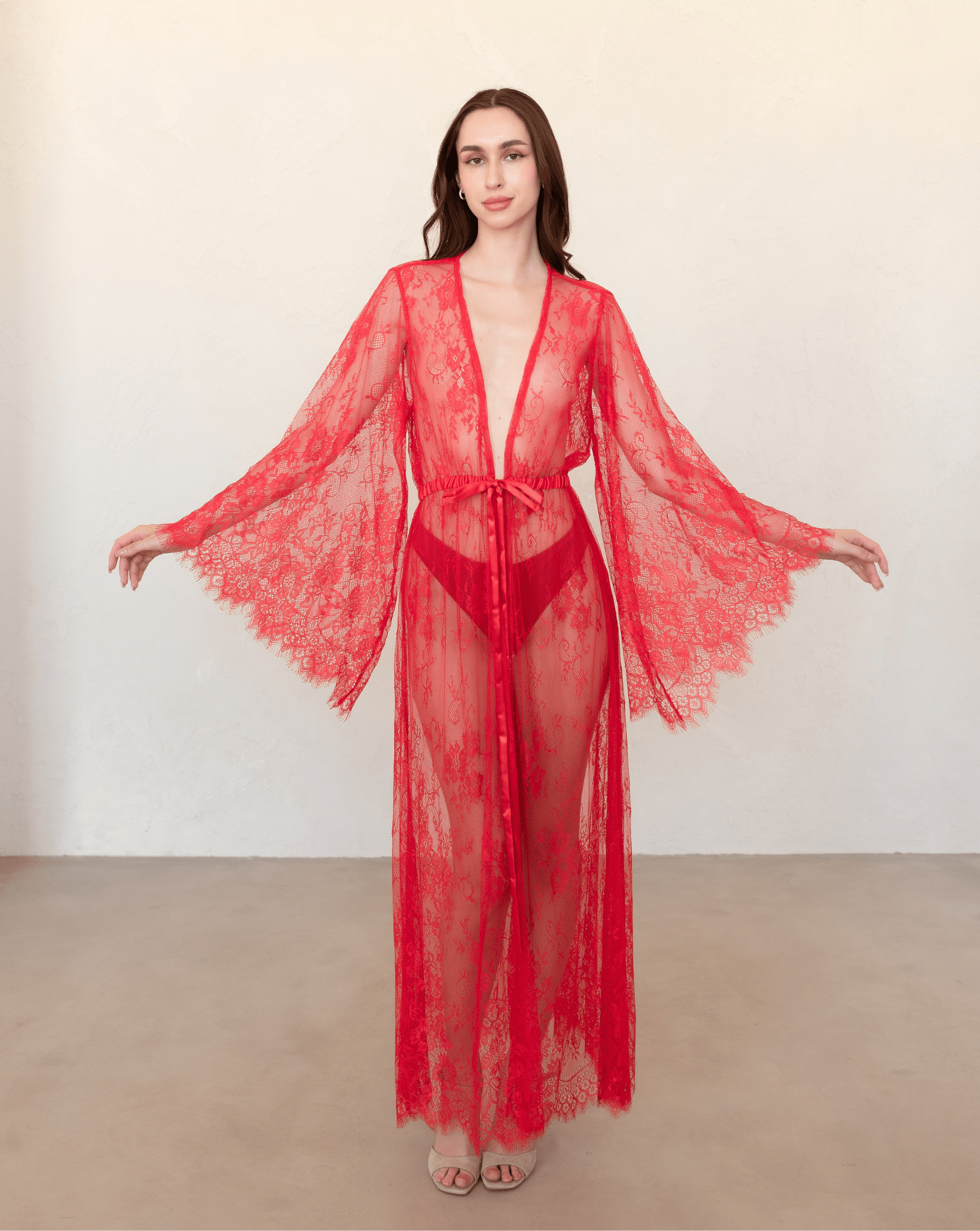 Red lace robe displayed with arms extended, highlighting lace sleeve and hem design.