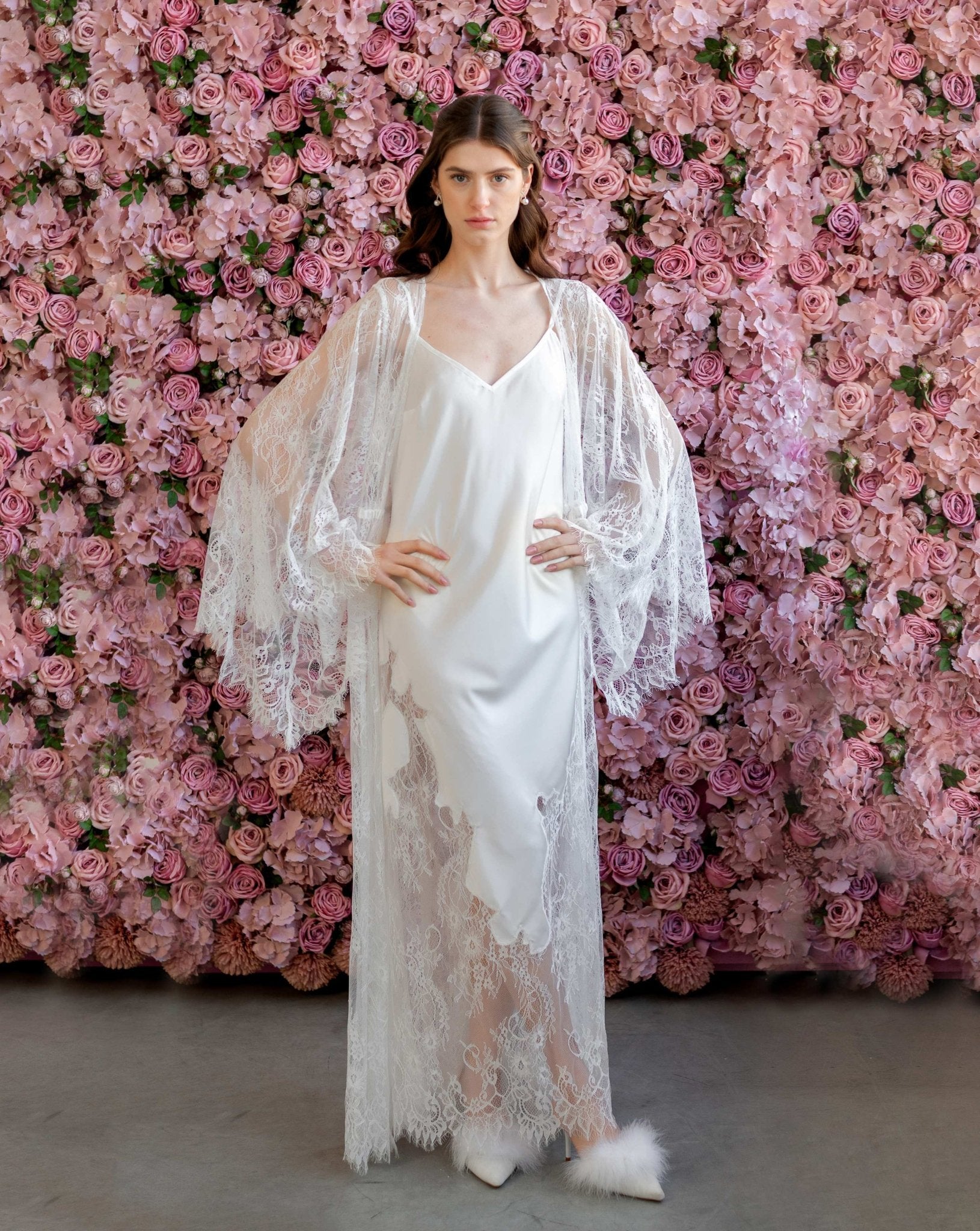 Elegant bridal model in sheer embroidered robe and white satin gown, floral backdrop - Kafemme Loungewear