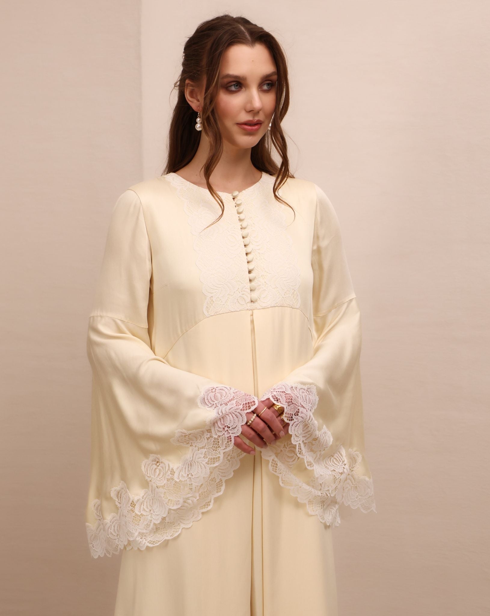 A mid-length shot focusing on the wide sleeves with fine lace that adds a romantic touch to every gesture.