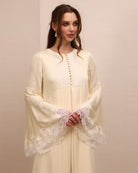 A mid-length shot focusing on the wide sleeves with fine lace that adds a romantic touch to every gesture.