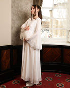 Side perspective highlighting the softly structured upper part and how the dress flatters a maternity silhouette.