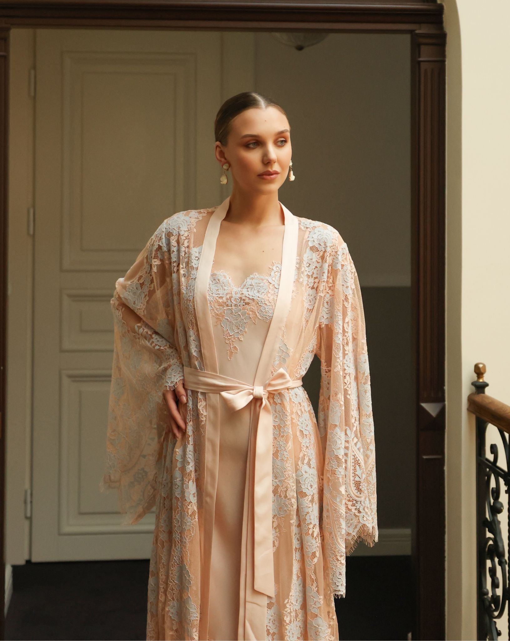 Mid-length shot of the belted robe, featuring wide sleeves finished with intricate and delicate lace work.
