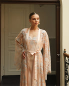 Mid-length shot of the belted robe, featuring wide sleeves finished with intricate and delicate lace work.