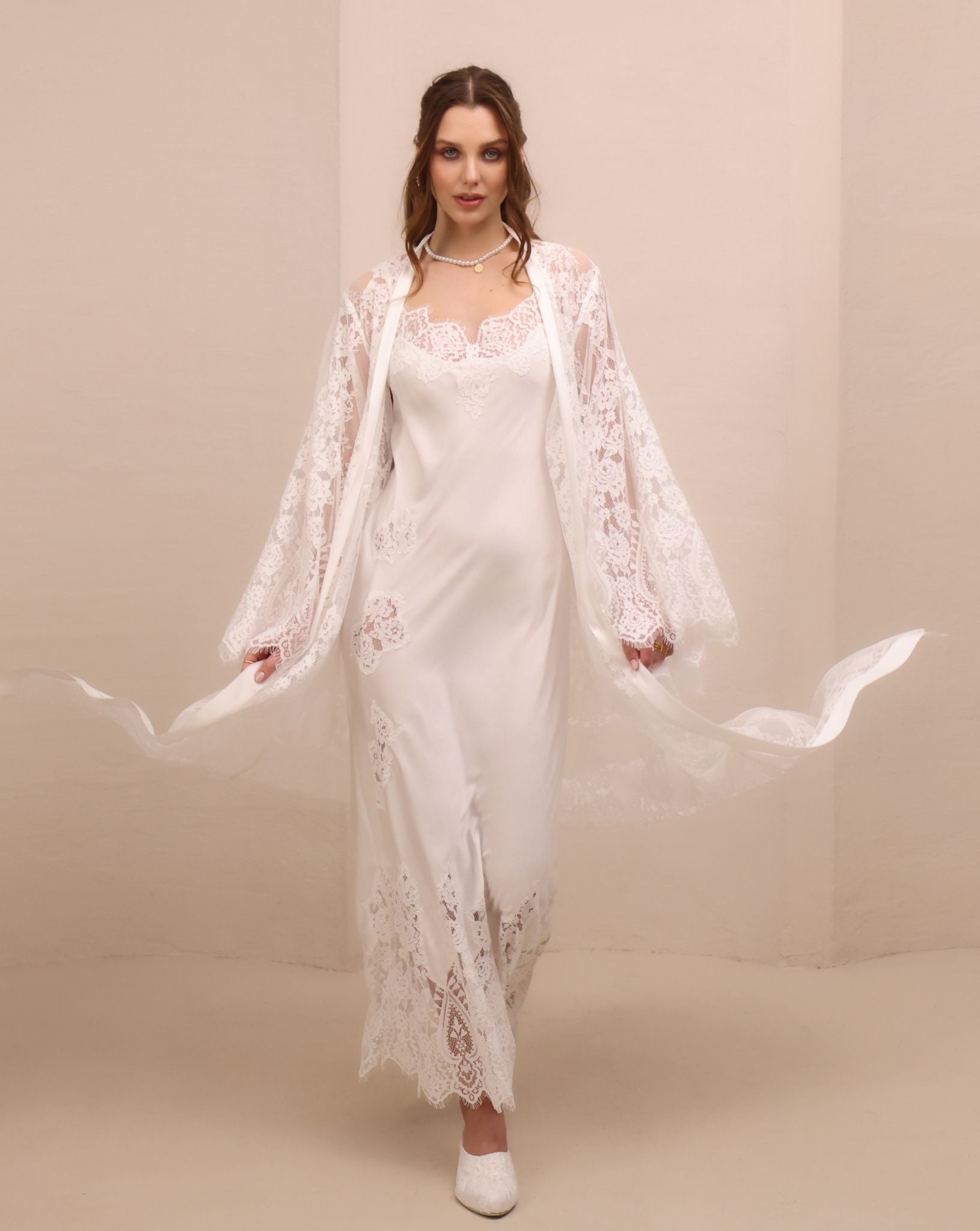 A dynamic motion shot of the lace robe flowing to both sides, capturing the airy movement of the floor-length cut.