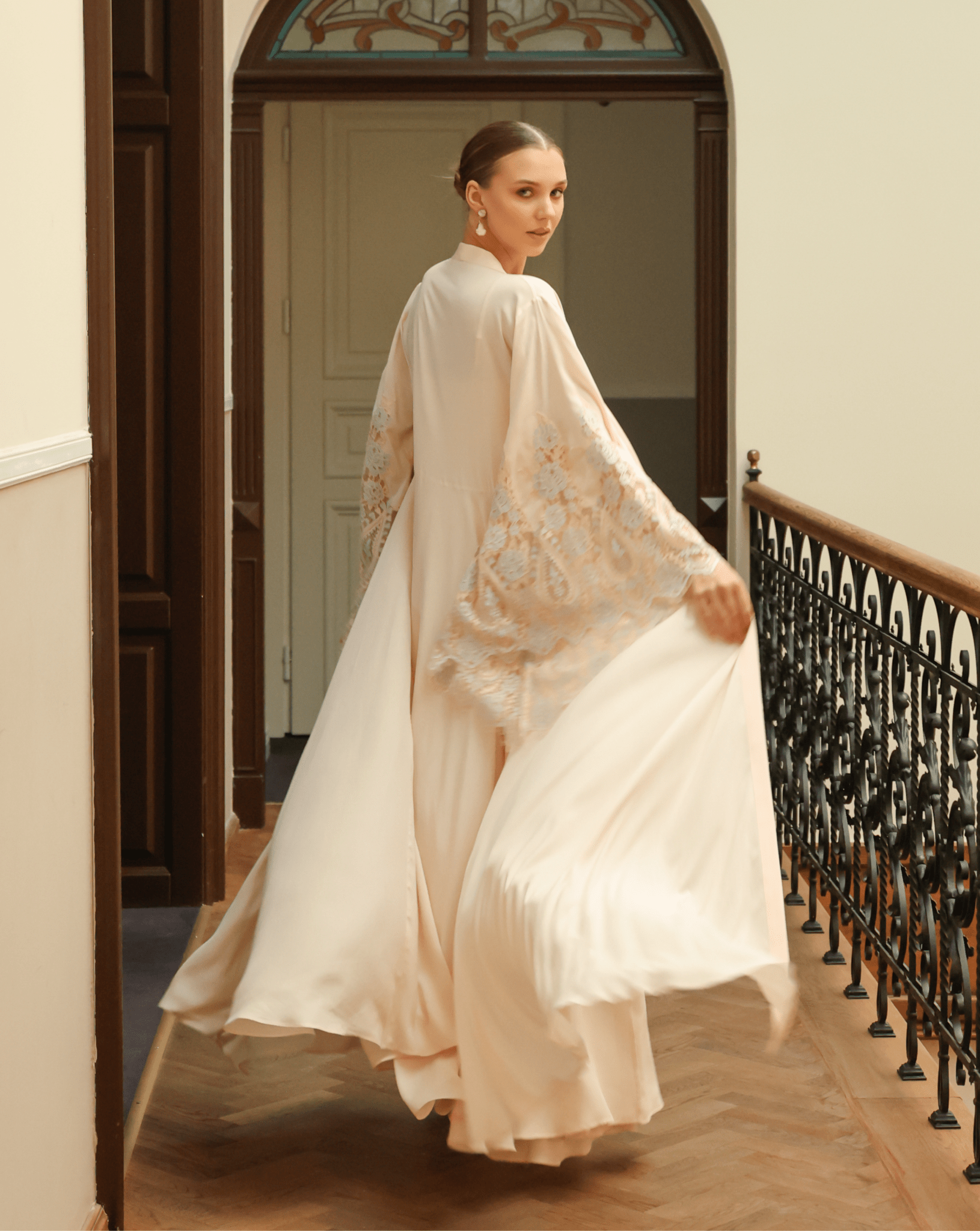 Rear view of a cotton-blend robe in a spinning motion, highlighting the graceful silhouette and ethereal drape.
