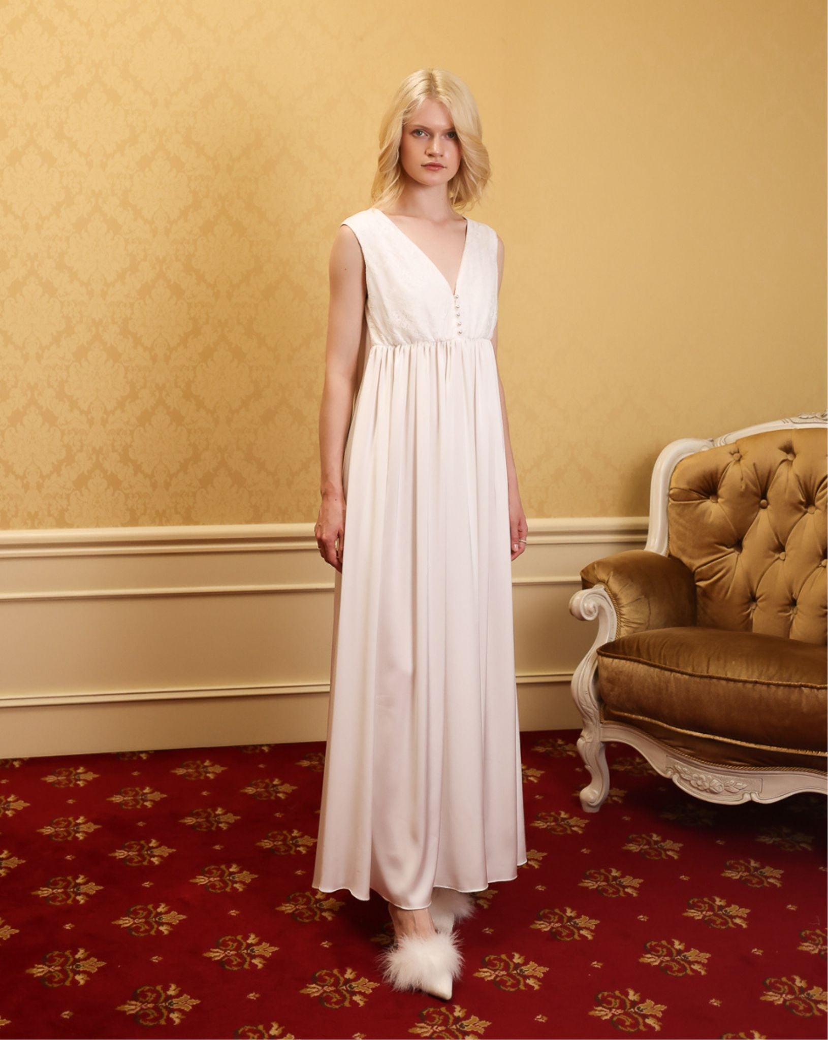 Front view of a white maternity nightgown with a loose fit, featuring delicate lace trim and functional buttons.