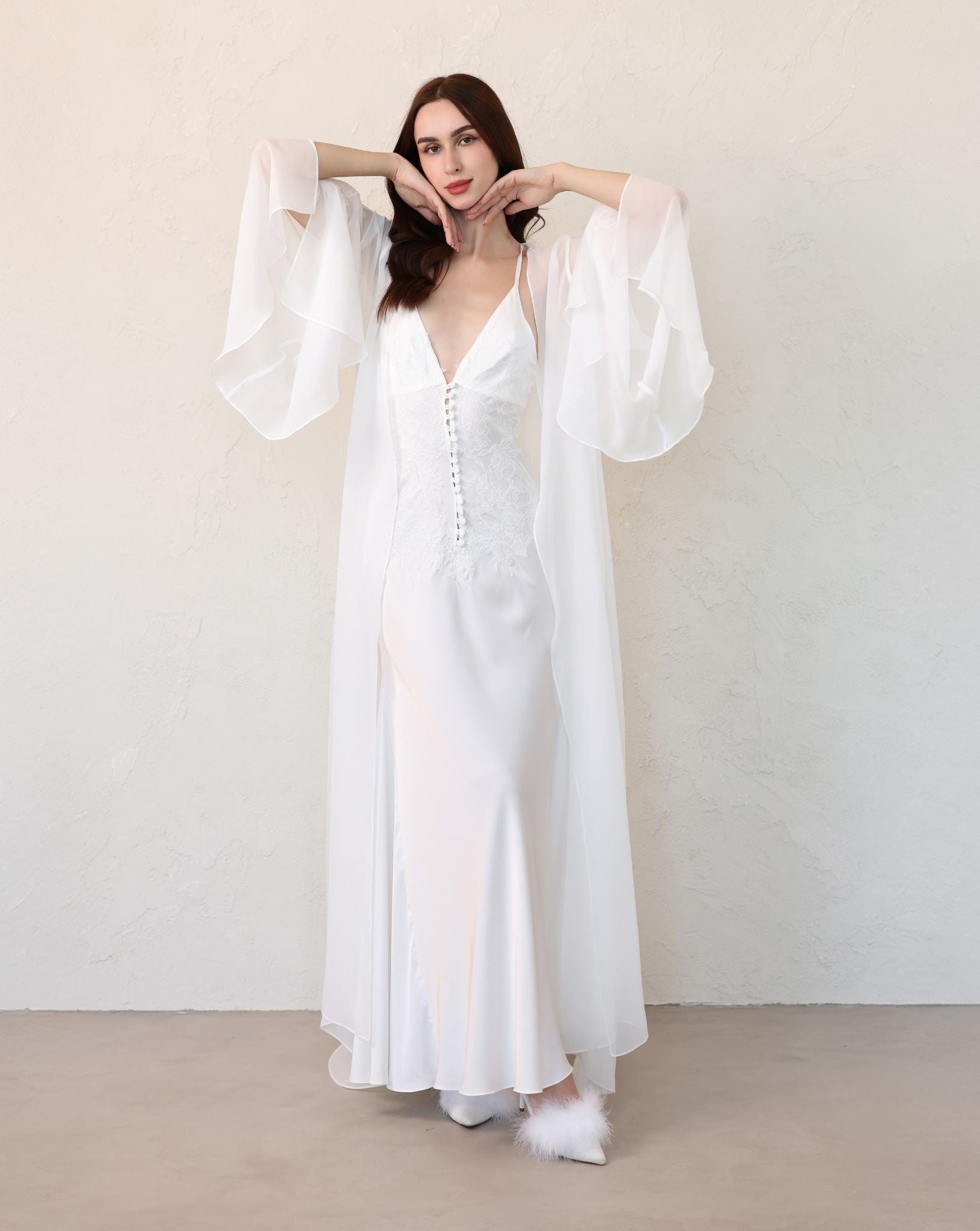 Front view of a white sheer robe with dramatic sleeve slits and lace embellishments, showcasing the airy, wide sleeves.