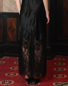 Detailed shot from the waist down, focusing on the visual contrast of the lace-trimmed hem and silk fabric.