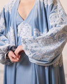 Close-up of the voluminous balloon sleeves adorned with delicate lace patterns, capturing the soft drama of velvet.