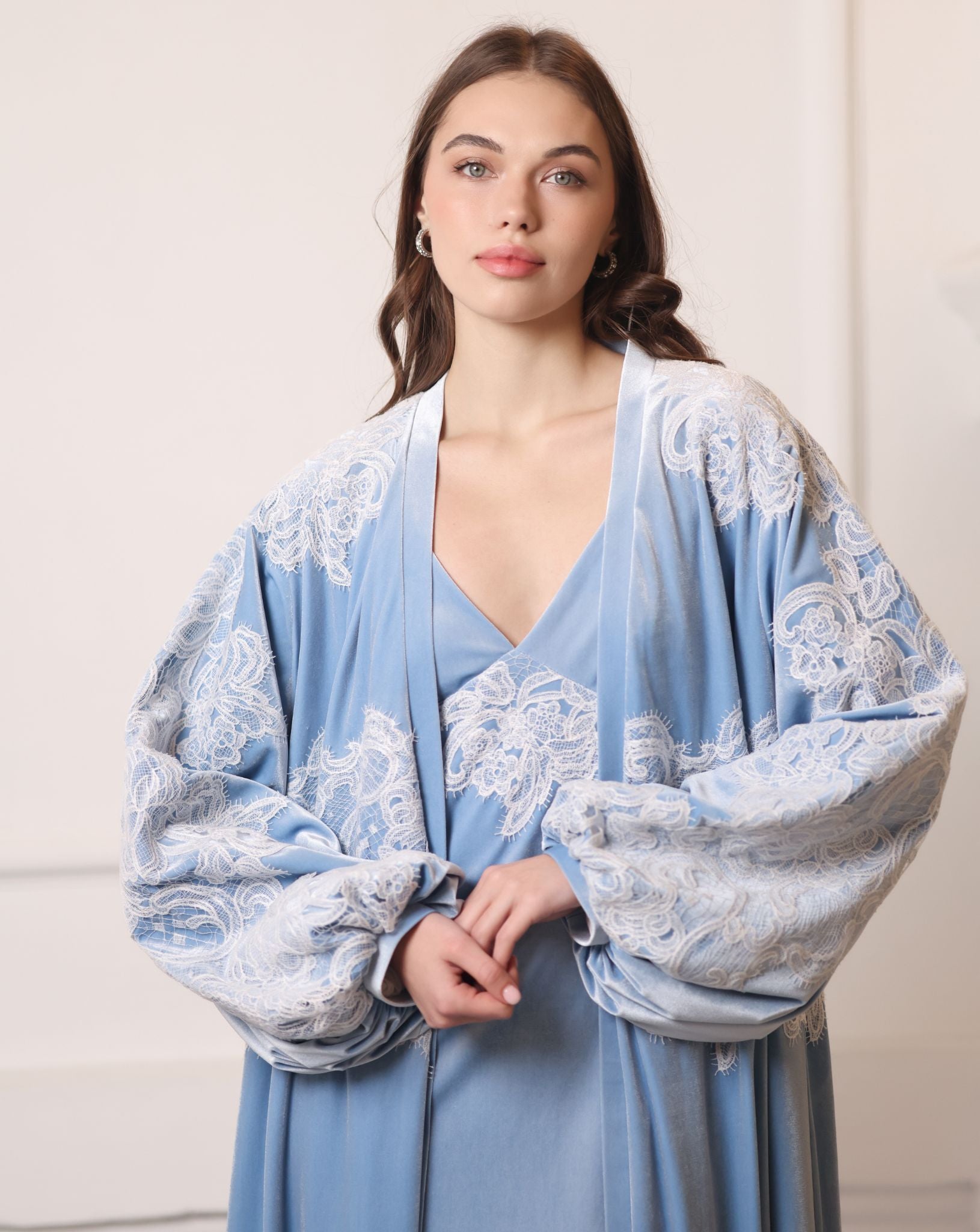 Shot from head to waist capturing the poetic movement of airy balloon sleeves with lace-trimmed wrists.