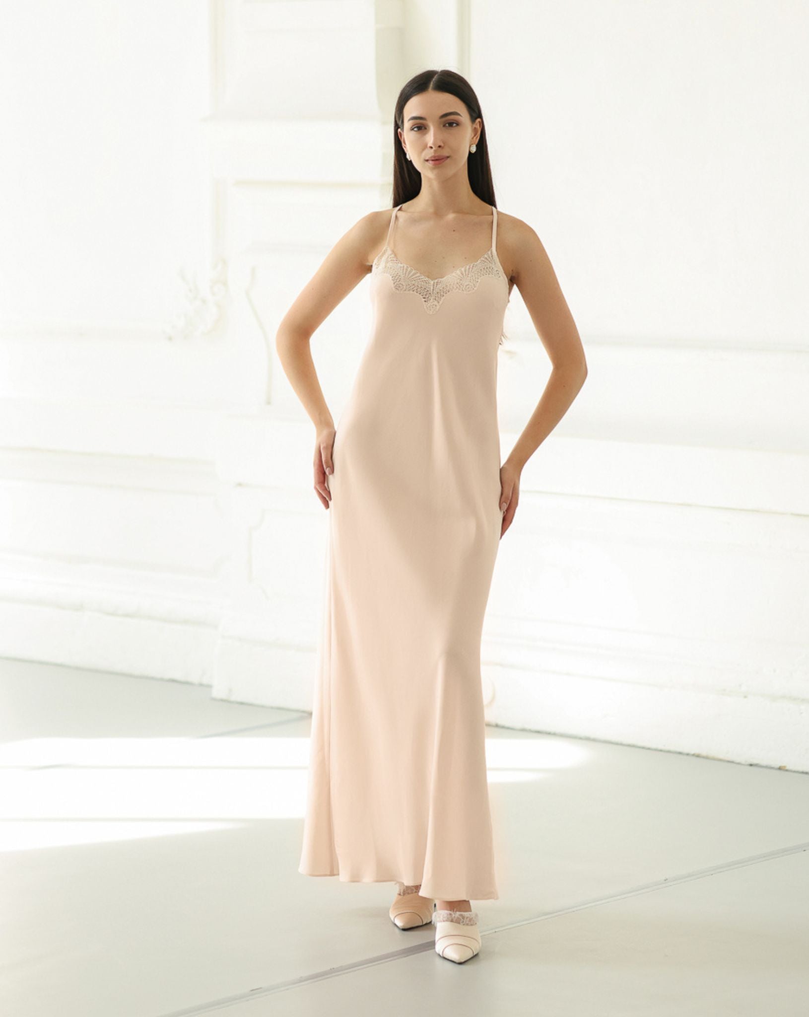 Standing in a lace-trimmed nightdress with hands on the hips, highlighting the soft texture and comfortable fit.