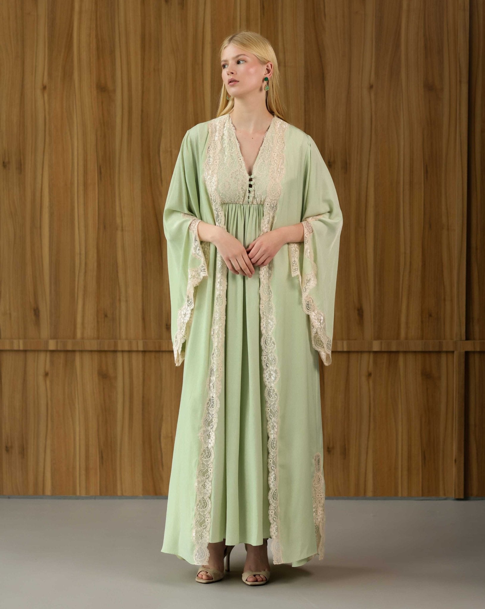 A standing pose with hands near the waist, highlighting the gentle support and functional design of the motherhood attire.