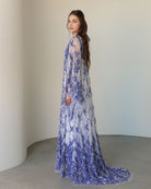 Side perspective of the attire, highlighting the graceful flow of the long lace train and the soft fabric.