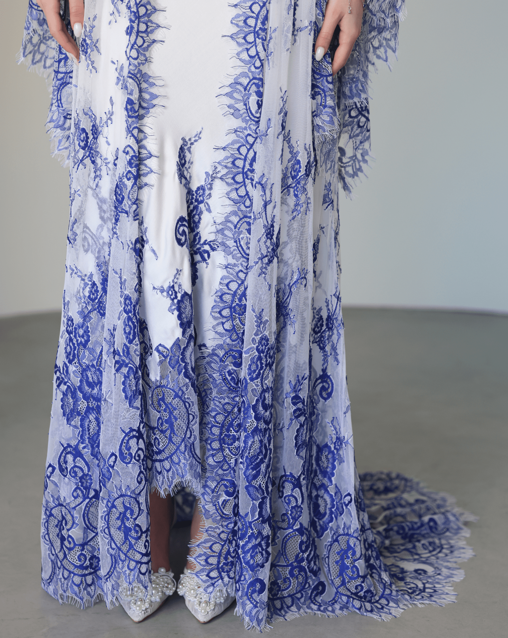 Close-up of the nightgown's hem, focusing on the fine lace patterns and the smooth texture of the material.