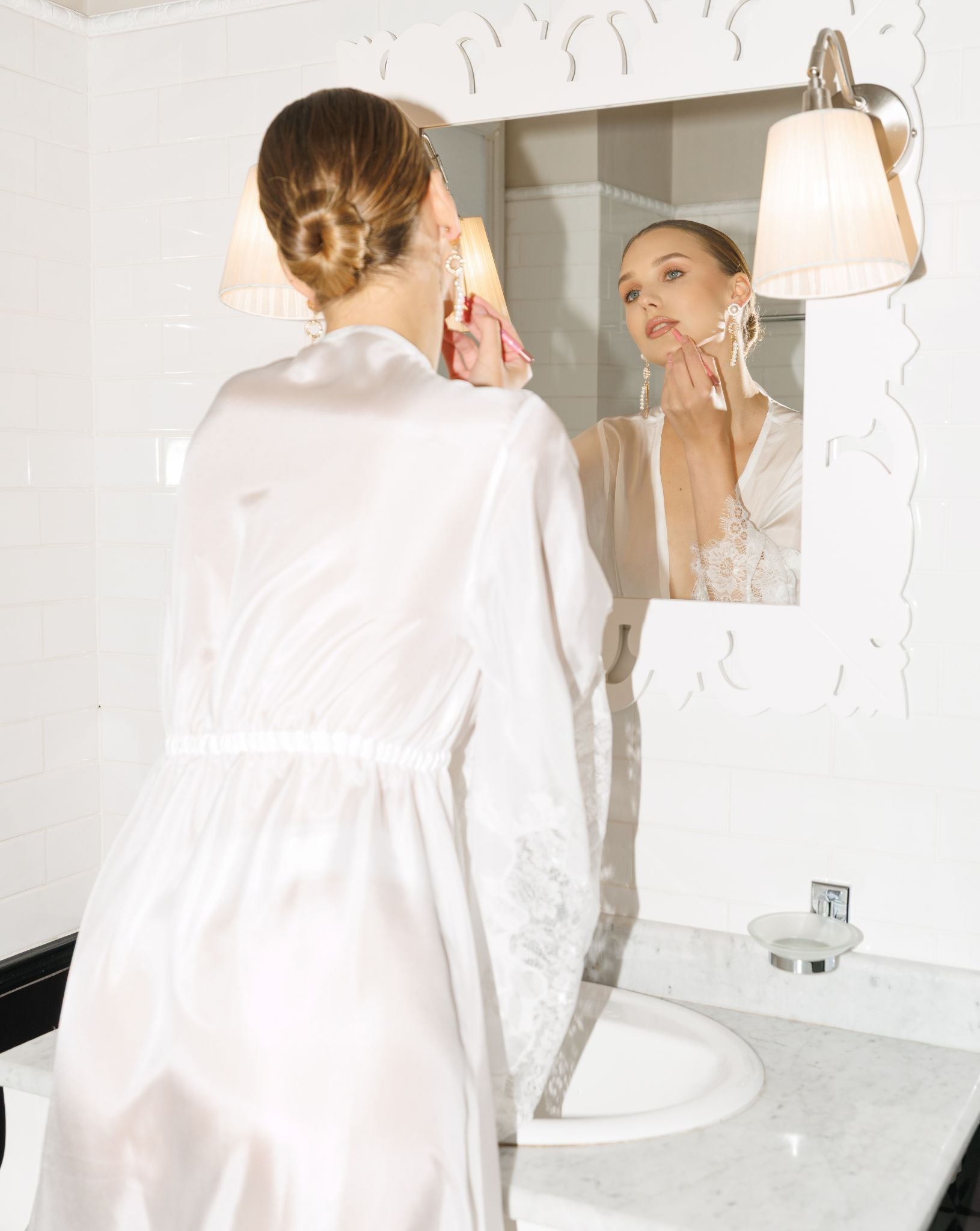 Back view of a sheer white silk robe for women, highlighting the flowing silhouette and delicate lace hem.