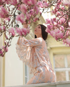 A poetic close-up of a girl smelling a magnolia flower, capturing a delicate moment of softness and character.