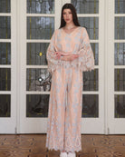Full-length shot of the Pajama Pants and Top with hands on hips, highlighting the wide statement sleeves with lace.