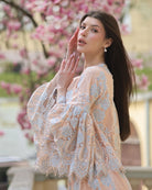 An artistic shot of a woman in a pajama set against a blooming magnolia, blending natural beauty with refined home wear.