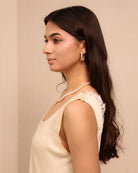 A close-up portrait focusing on the refined lace details and the practical shoulder buttons of the maternity set.