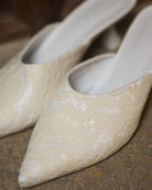 A close-up of the Satin Slippers, showcasing the pointed-toe silhouette and luminous satin finish.