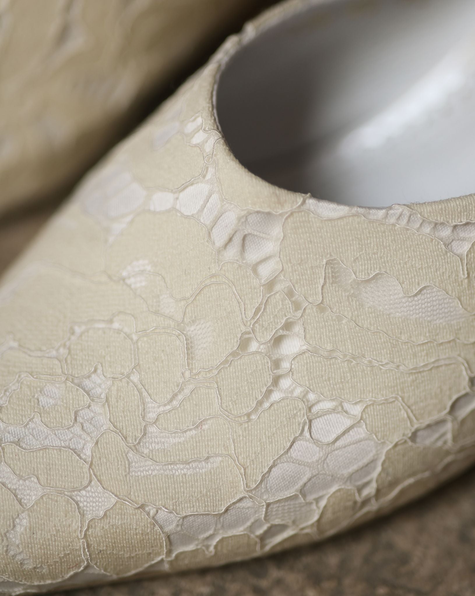 Macro shot of the slipper, focusing on the intricate lace adornment and the high-quality satin texture.