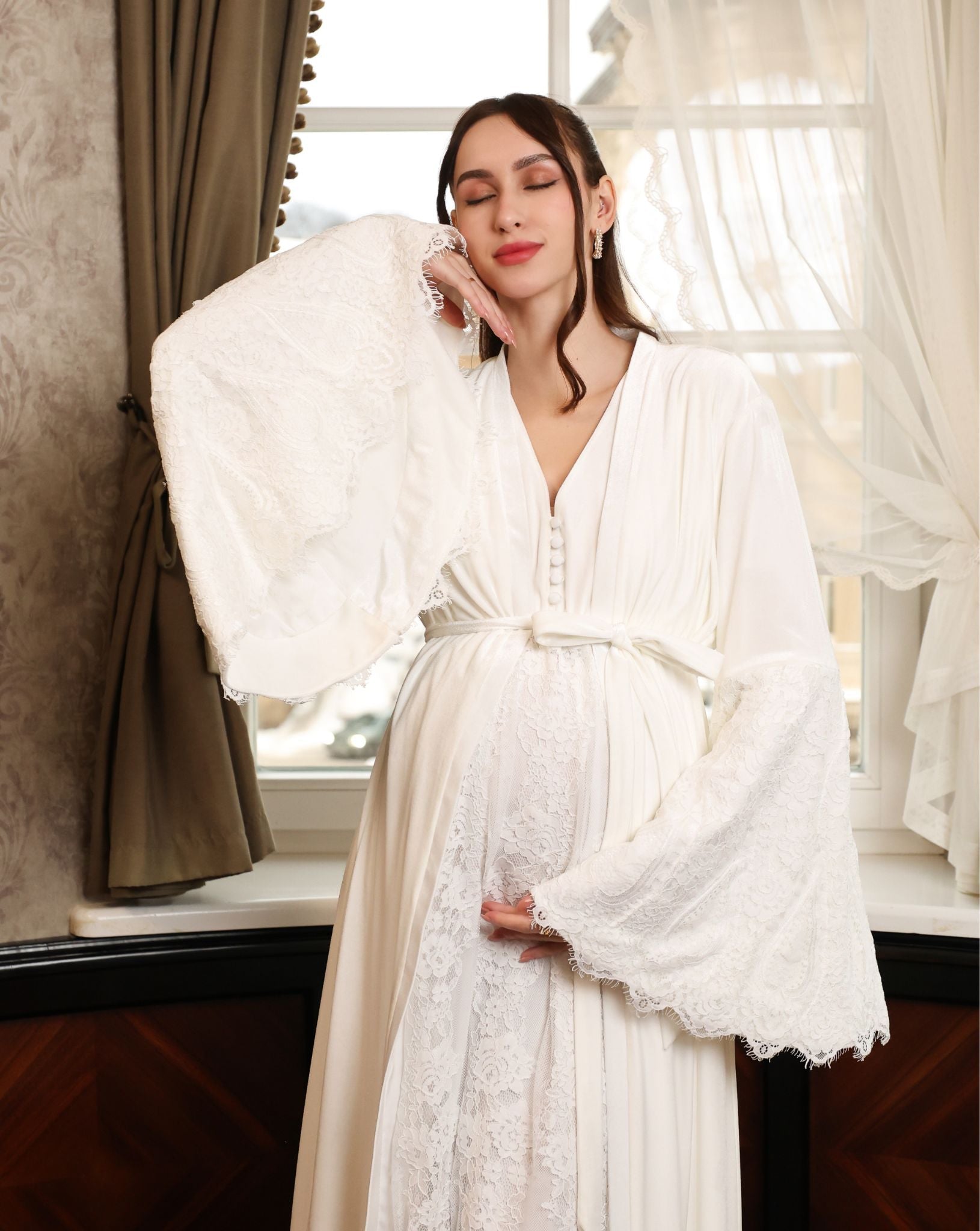 A pose featuring the tied robe with a focus on bell sleeves adorned with French lace trim.