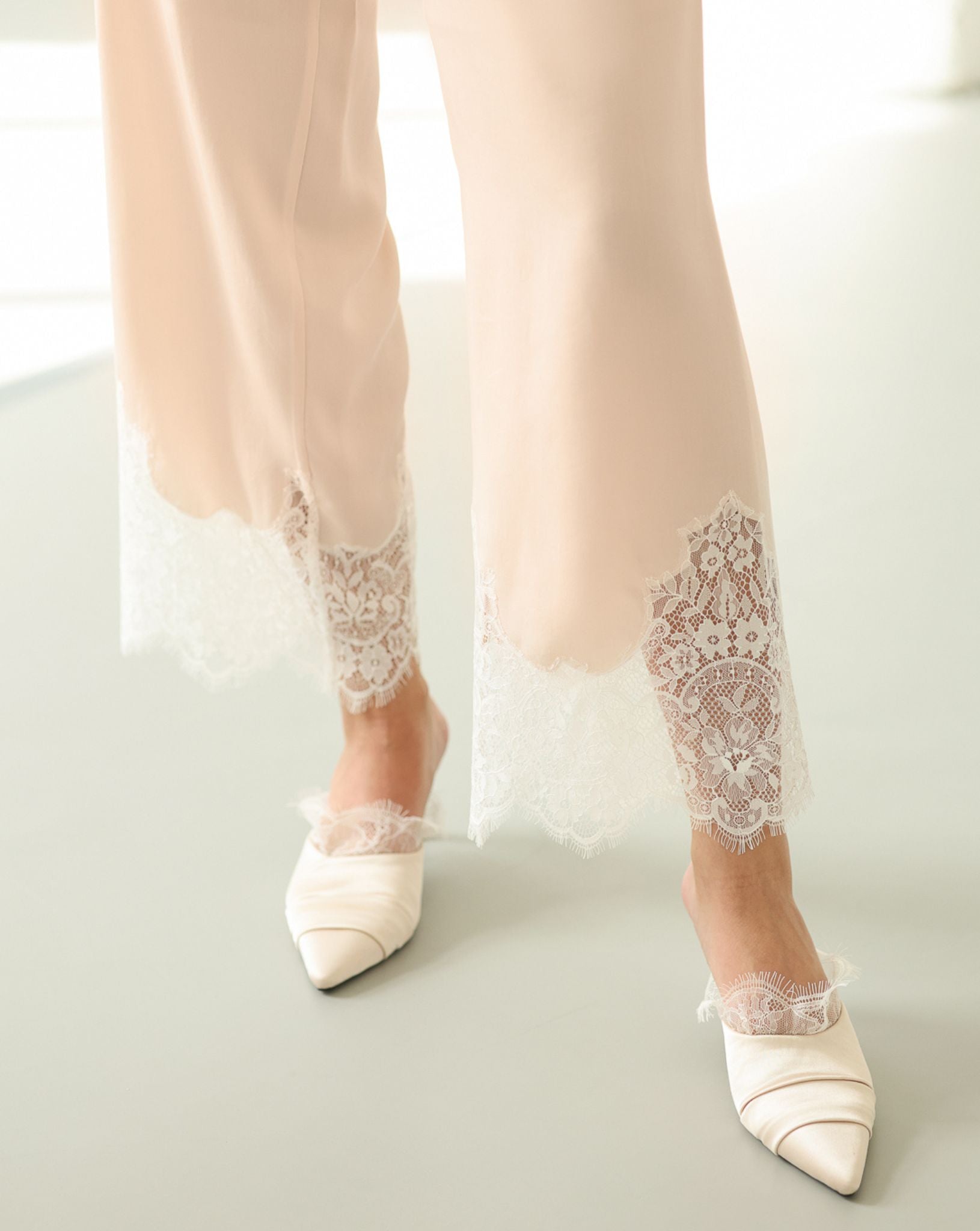 Detailed shot of the lace-trimmed hem on the trousers, showing the high-quality craftsmanship of the cotton-viscose blend.