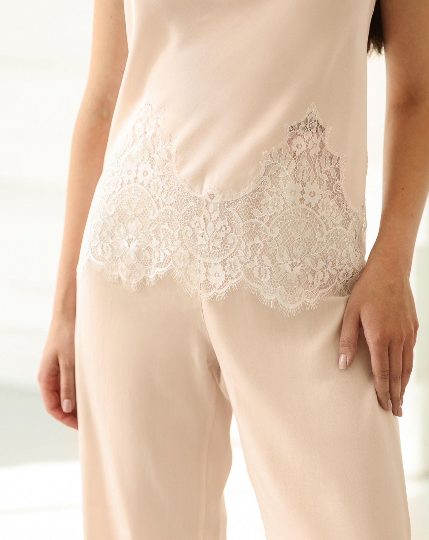 Close-up of the delicate floral lace embellishing the bottom of the soft cotton tank top for a feminine touch.