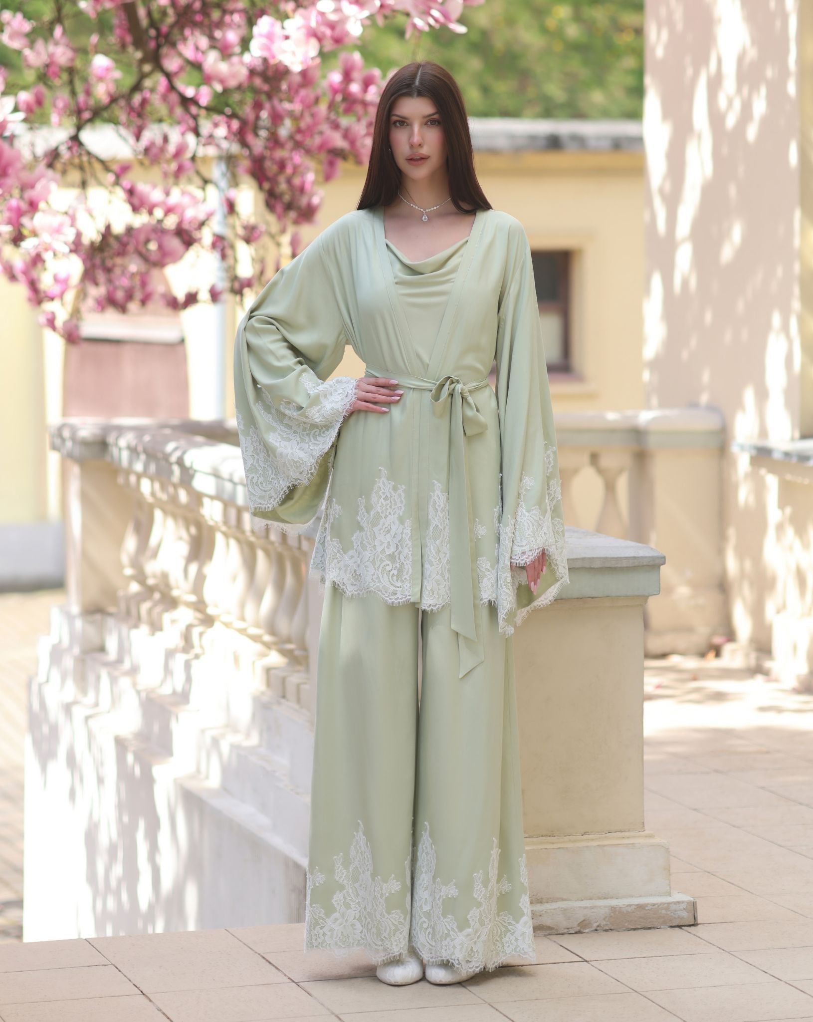 A poised view of the ensemble with one hand on the waist, showcasing the sophisticated drama of the kimono sleeves.