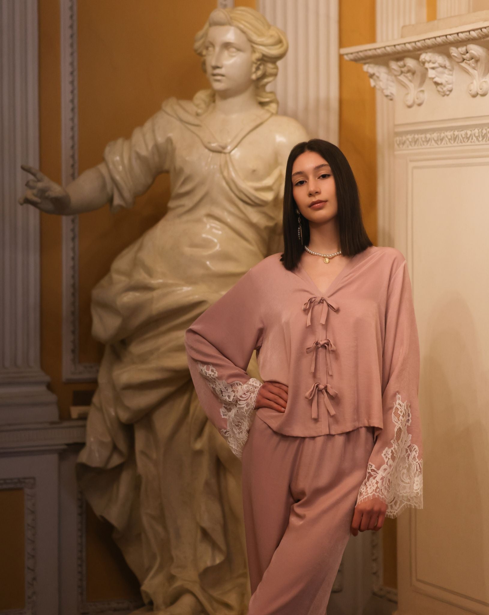 A creative shot of the set next to a sculpture, capturing the natural and elegant aesthetic of the nightwear.