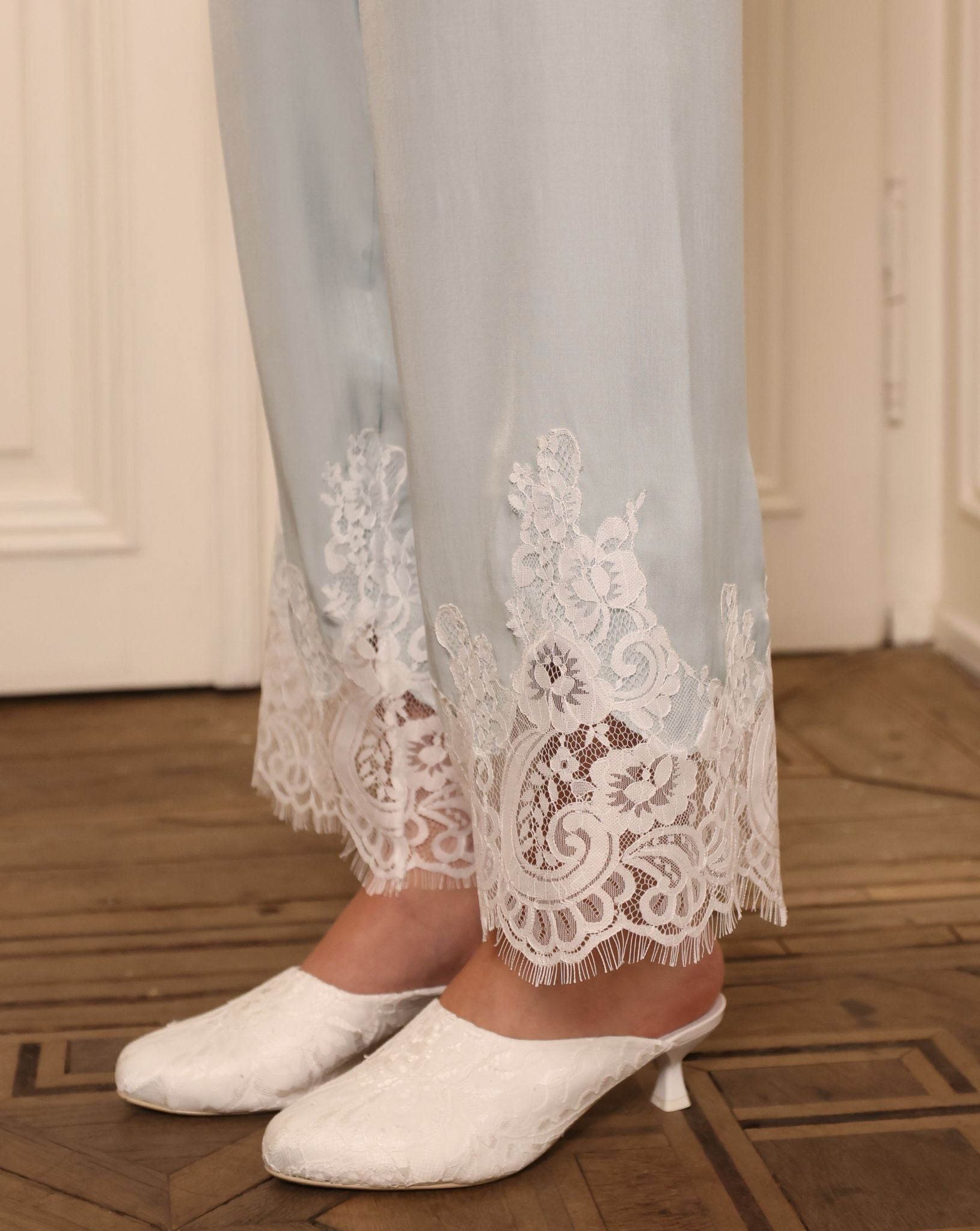 Close-up of the trouser hem, focusing on the lace accents