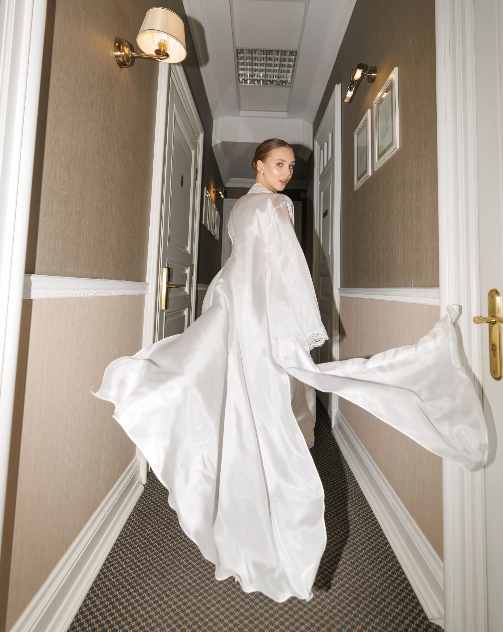 Creative shot of a woman running through a corridor, featuring the flowing semi-sheer silk habotai robe in motion.