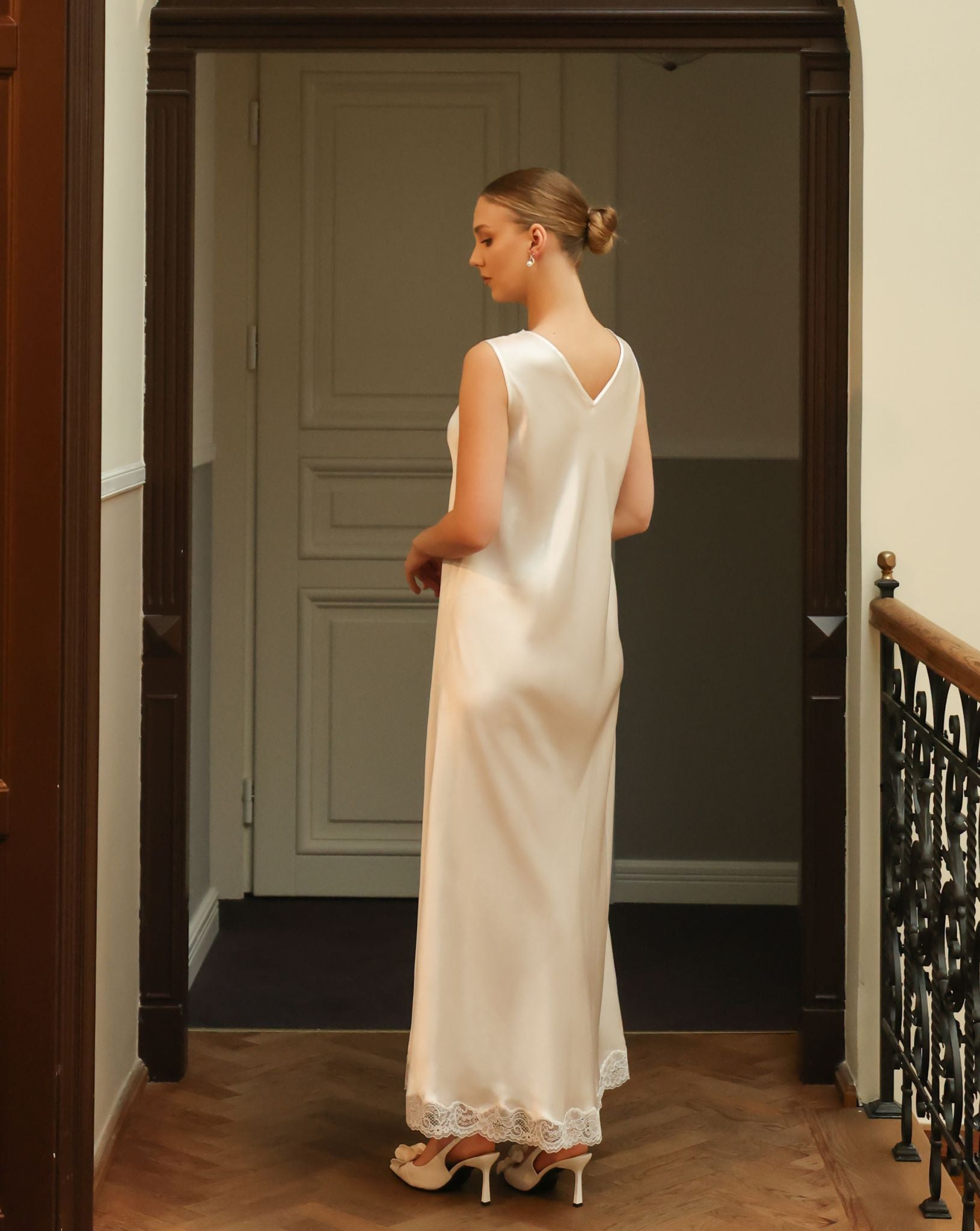 Rear view of a silk satin nightgown, focusing on the conservative V-cut back adorned with delicate floral lace patterns.