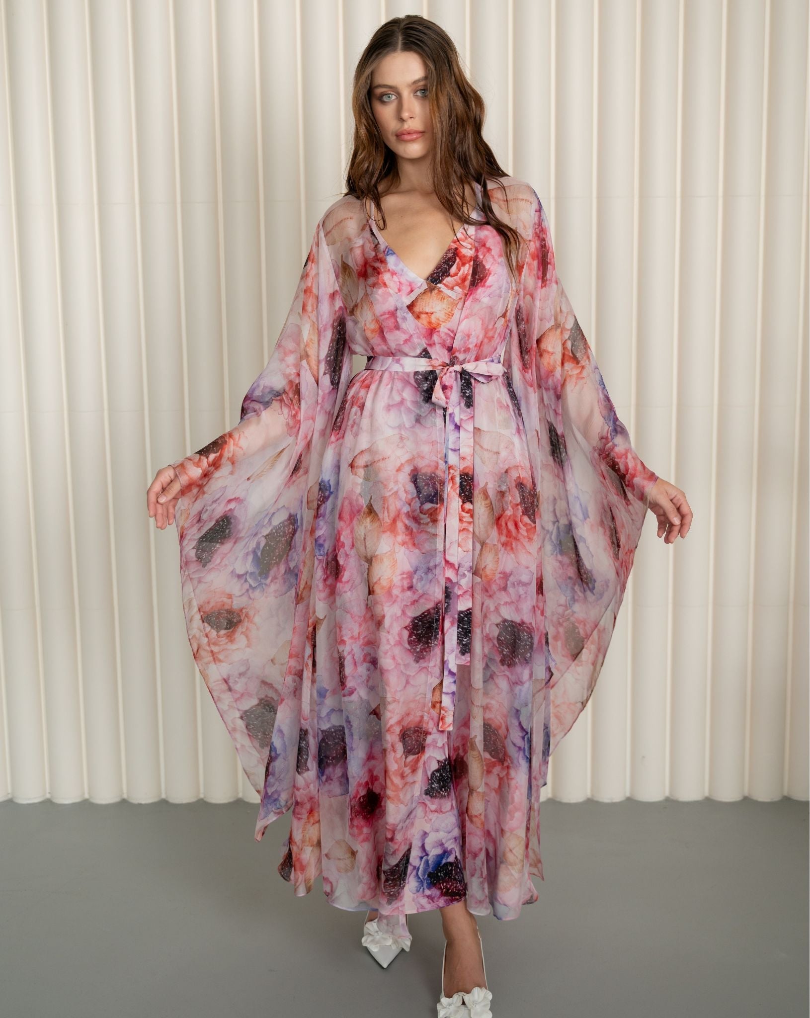 Front view with slightly raised arms to display the artistic floral design and structural cut of the silk sleeves.