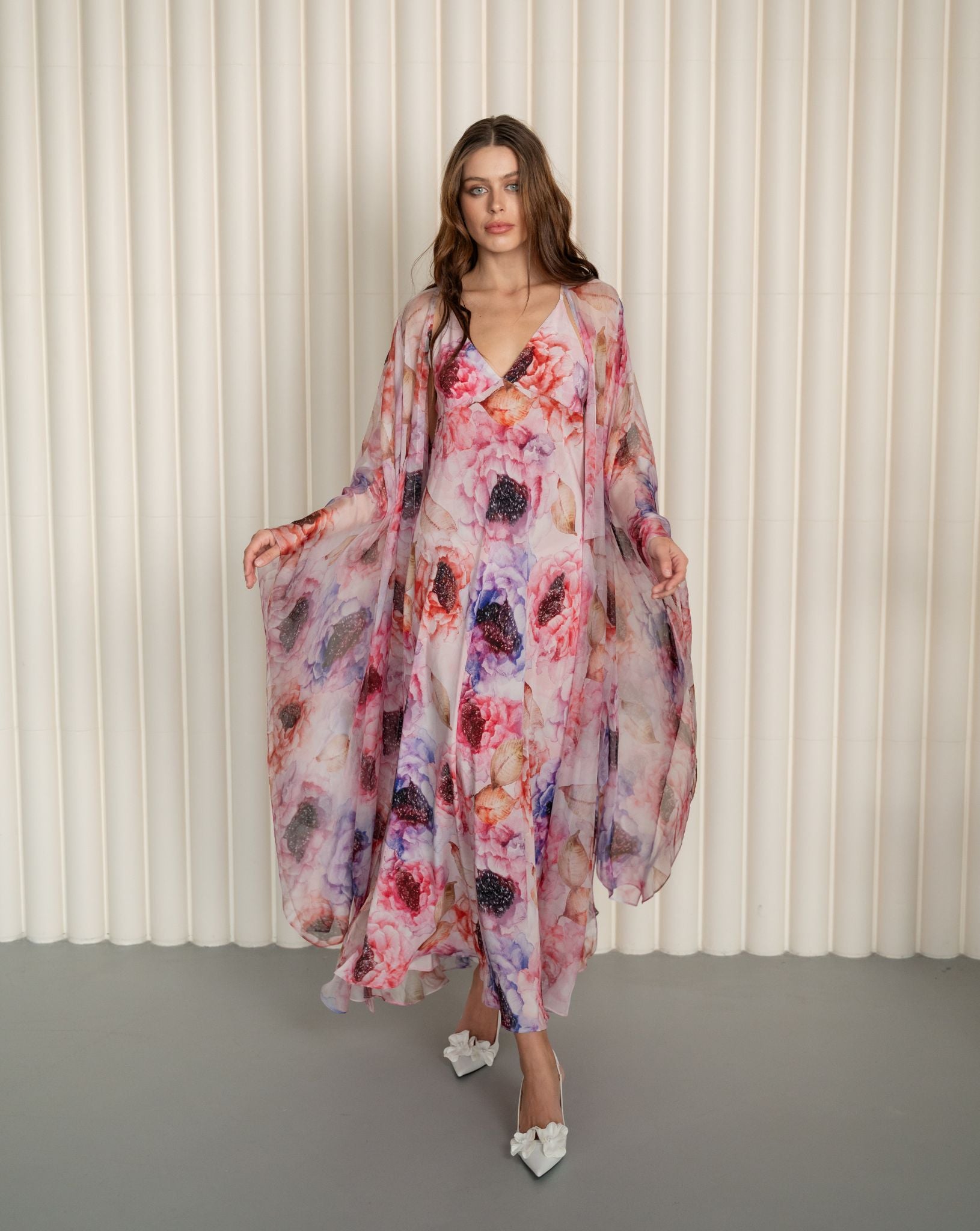 Full-length shot of a walking woman, featuring the airy movement of a floor-length sheer silk wrap-over robe.