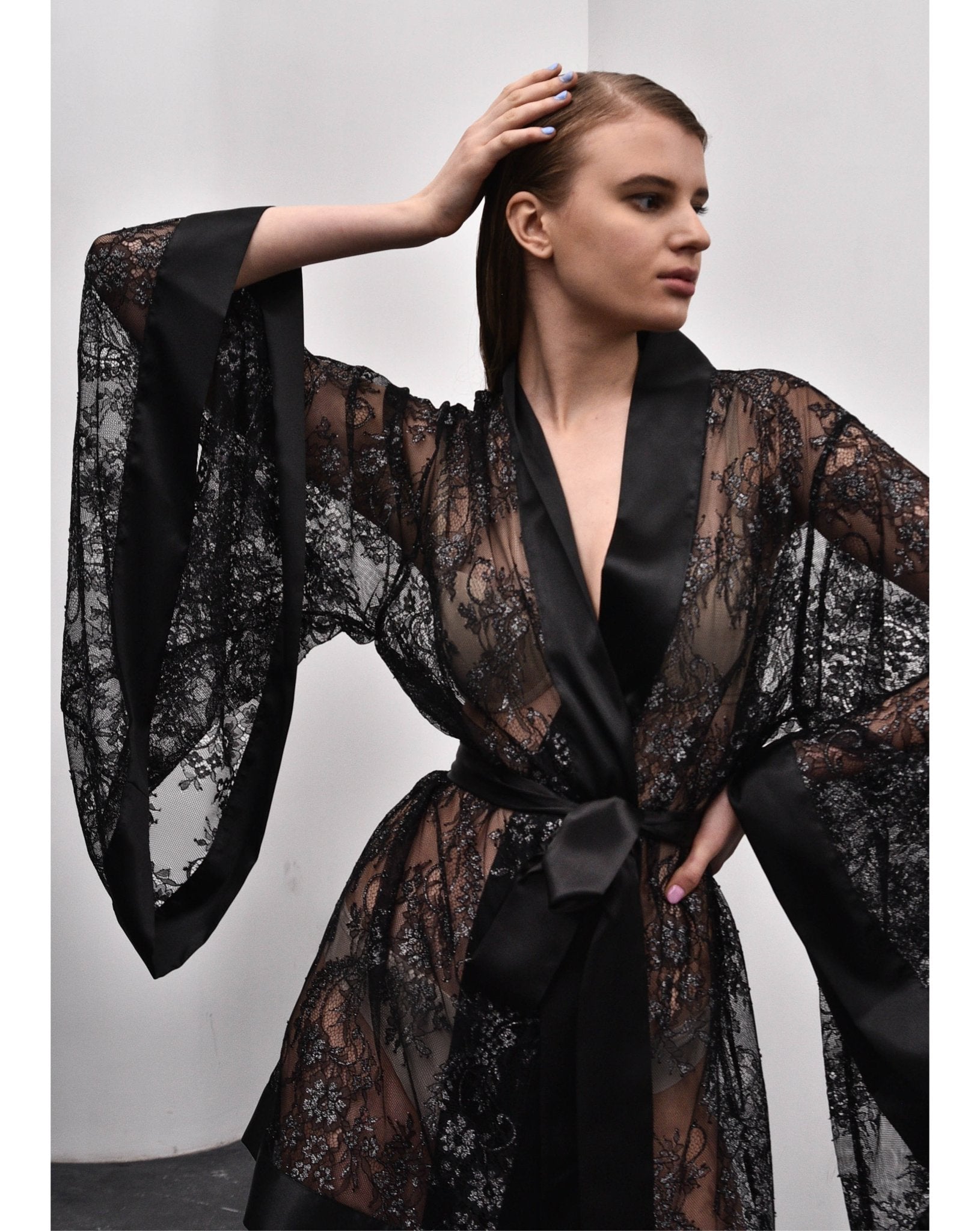 Close-up of black kimono robe with wide sleeves and satin belt