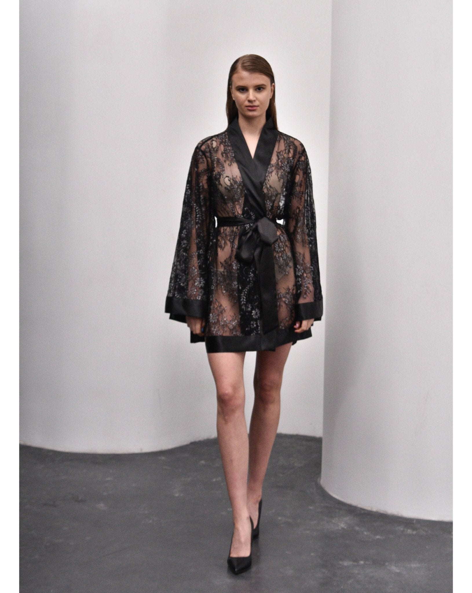 Model standing in black lace kimono with V neckline